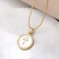 Elegante gouden parelketting met kruishanger op een wit marmeren achtergrond - Stijl B-Rond Kruis