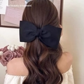 Elegant oversized black satin bow hair clip accessory shown on a model's hairstyle - Black Simple Bow Duckbill Clip