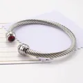 Bracciale rigido a fune in acciaio argentato con una vibrante pietra di zircone rosso - Gennaio/Rosso
