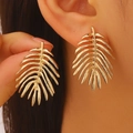 Golden oversized palm leaf earrings with irregular textured finish on a female model - Hollow Multi-layer Leaf Shape (WG-0344) / Gold