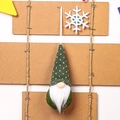 Detail of a green knitted Christmas gnome ornament with white heart pattern and long beard - Green Type A