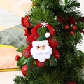 Detail of plush Santa Claus ornament with green snowflake embroidery on a red tree base - Santa Claus