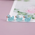 Three glowing blue resin ducks with glitter flakes in a cute miniature landscape display - Sky Blue