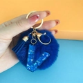Detail of dark blue faux fur pompom keychain with sequined letter V and elegant tassel - Letter V