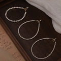 Detailed close-up of three pearl bracelets with gold clasps on vintage paper - 4mm Round Artificial Pearl Bracelet