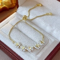 Detailed macro view of adjustable gold flower bracelet with zircon stars in a jewelry box - Real Gold Plated Star Flower Style