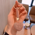 Close-up of a sparkling pink rhinestone heart keychain with gold metal ring detail - Pink