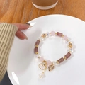 Detail van kralenarmband met roze aardbeienkwarts en gouden schelphangertjes bedeltjes - Aardbeienkwarts / Roze