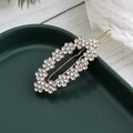 Elegante pinza ovalada dorada con cristales brillantes sobre una bandeja cerámica - Estilo Diamante De Imitación (C4121)