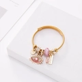 Golden steel rope bracelet featuring evil eye charms and pink beads on white background - Pink