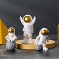 Set di tre figurine di astronauti in resina bianca con visiere dorate su marmo nero - Un Set Oro