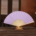 6 inch lavender paper folding fan with carved bamboo frame on a wooden display stand - Light Purple