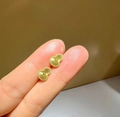 Vintage golden gourd earrings with radiant texture held between fingers for size - Gold Radial Texture Gourd