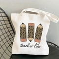 White canvas tote bag with teacher life leopard pencil print on a black chair - Teacher Life Leopard Pencils