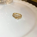 Detailed view of a gold cubic zirconia buckle ring on a white ceramic plate - Gold Belt Buckle Zircon