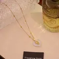 Gold-tone heart necklace with a white gemstone pendant and small figure detail - 7# Opalite