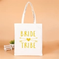 White canvas tote bag with golden Bride Tribe print for bridesmaid gifts and bridal showers - Style D (Bride Tribe/Gold Arrow)
