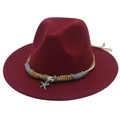 Dettaglio del cappello fedora bordeaux con ciondolo a stella e fascia in metallo - Borgogna