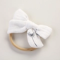 Detailed macro view of white muslin baby headband with black dandelion print and elastic band - Dandelion