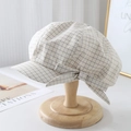 Dettaglio di un berretto a scacchi con fiocco su un supporto in legno in stile vintage - Griglia Bianca / M (56-58cm)