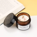 Soy wax scented candle in a brown glass jar with pink dried flower petals on top - Peach Blossom