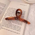 Brown tortoiseshell matte hair claw clip for thick hair displayed on a book page - 11cm / Tortoise