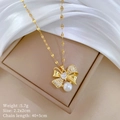 Macro shot of gold bow necklace pendant with zircon and pearl on silk background - Titanium Steel Chain Copper Pendant / Bowknot Necklace (B521)