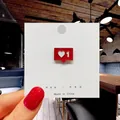 Detail of red heart enamel pin for bags and clothes shown on a white card display - 139*Heart Social Media Like Pin