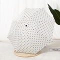 Ombrello a manico lungo beige a pois marroni esposto su un tappetino intrecciato - Manuale Bianco Pois Caffè