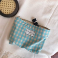 Detail der blau-orangen Kosmetiktasche mit Karomuster und TIME TO PARTY Etikett auf Strickware - Tiffany Blau Gitter