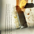 Essential oil roller bottle with yellow natural crystals and bamboo lid on a book - Citrine