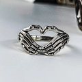 Detailed macro view of two skeleton hands forming a heart shape on a vintage silver ring - Heart Skeleton Hand / Antique Silver