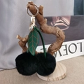 Close-up of fluffy black cherry keychain with green leather leaves on a branch - Black