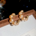 Dettaglio macro di orecchini a cerchio a C placcati in oro con perle in stile francese - Stile Perla a Forma di C Placcato Oro / Champagne