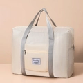 Cream quilted travel bag with gray handles and waterproof fabric on warm background - Beige