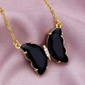 Macro shot of gold butterfly pendant with faceted black crystals and clear stones - Black