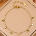 Elegante pulsera de acero de titanio dorado con dijes de estrellas y piedras de circón - Trébol Dorado