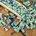 Makro-Detail handbemalter hellgrüner Keramikperlen mit Tintenspritzern auf einem Holzlöffel - Zyan Violett (Bemalt 6x12mm)