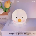Cute octopus-shaped white night light with yellow mouth placed on a book as a gift - Octopus White