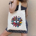 Canvas tote bag with colorful graffiti evil eye print shown on a model in a street style - STD1804-U HELLO Sun Flower Eye