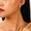 Golden bow jewelry set with white pearls featuring matching earrings and ring on model - Pearl Stud Earrings & Ring Set