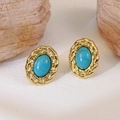 Vintage oval turquoise stud earrings with braided gold texture on light stone surface - Blue