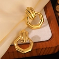 Elegant gold hexagon earrings with vintage stripes texture displayed on silk fabric - Gold Hexagonal Vintage Striped Earrings