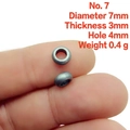 Macro shot of 7mm metallic spacer bead on fingertip showing precise dimensions and hole - 7# (7x3mm)