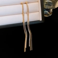 Close-up of golden tassel earrings with sparkling rhinestones on a jewelry box - Gold
