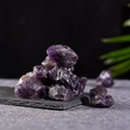Natural raw amethyst crystals displayed on a dark stone base with a refined setup - Purple Crystal Stone (150g)