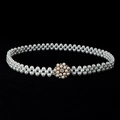 Detail view of white pearl belt featuring a gold rhinestone buckle on black background - Gold-Tone Base Rhinestone Artificial Pearl Round Button (Style 9)