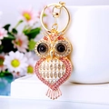 Close-up of golden owl keychain with pink rhinestones and white enamel details - Heart Owl Pink