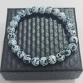Blue spotted natural stone energy bead bracelet displayed on a black jewelry box - Quail Egg