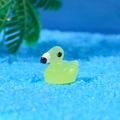 Translucent luminous miniature duck figurine in light green on blue sand base - Green